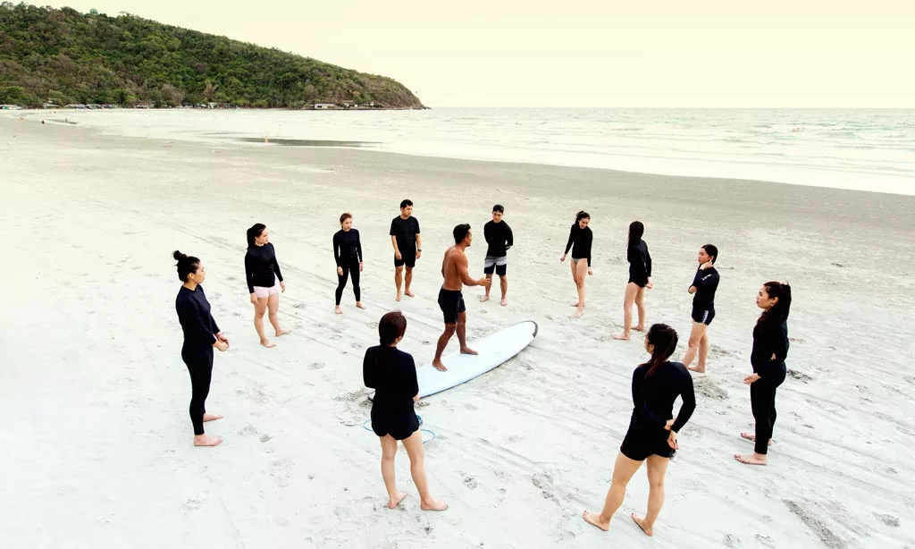 A group of people preparing for surf therapy