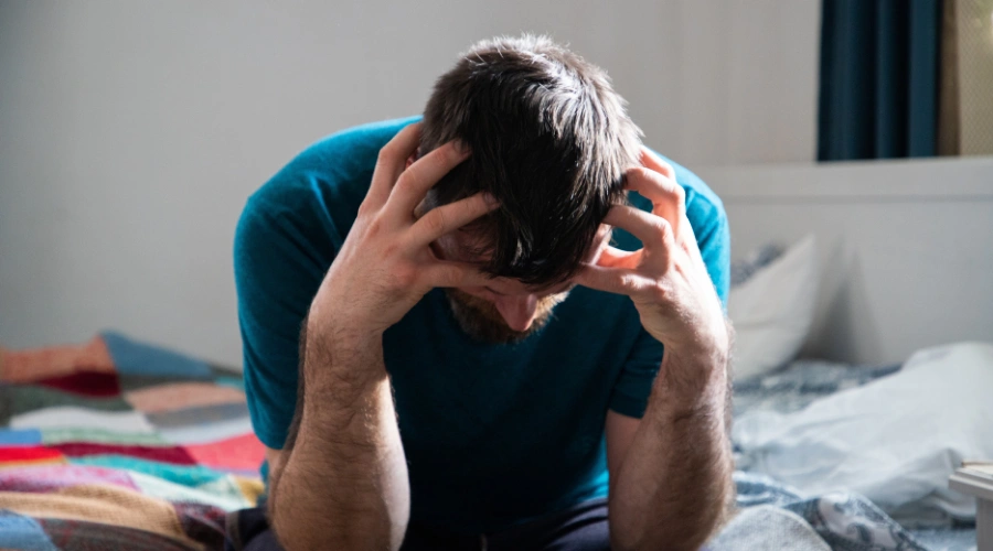 Image of a person looking drowsy and fatigued, illustrating sedation from high kratom use