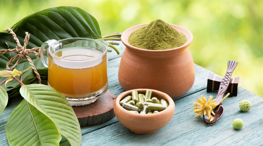 Image of kratom leaves and powder on a table, representing its effects on mood and stimulation