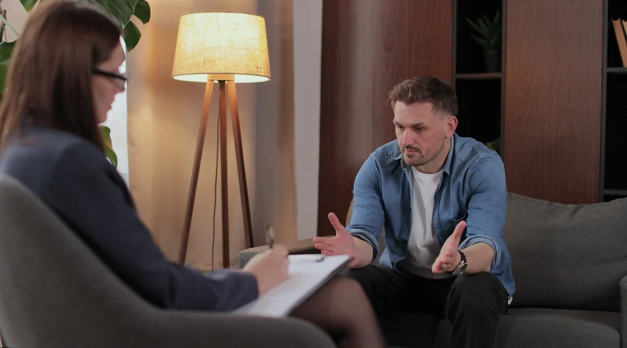Image of a therapist conducting a counseling session with an adult patient as part of addiction treatment